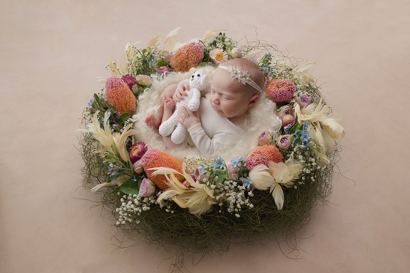 baby girl lying in a floral nest in a photography studio in Perth, Western Australia