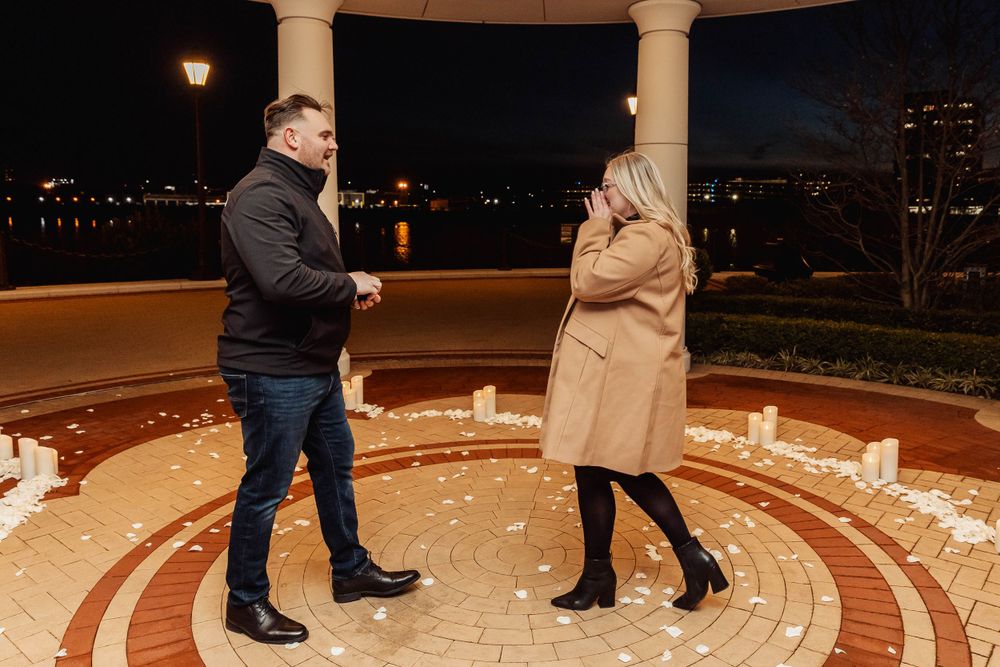 Couple sharing romantic moment in illuminated gazebo at night.