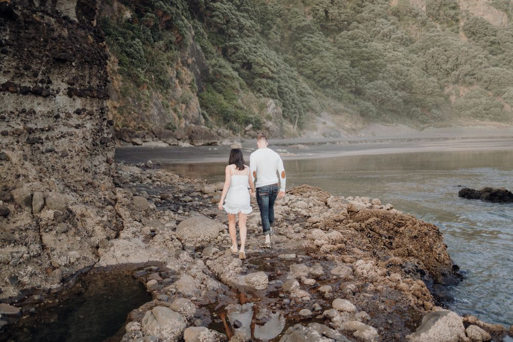 A romantic stroll along the rocky cliffside beach during golden hour.