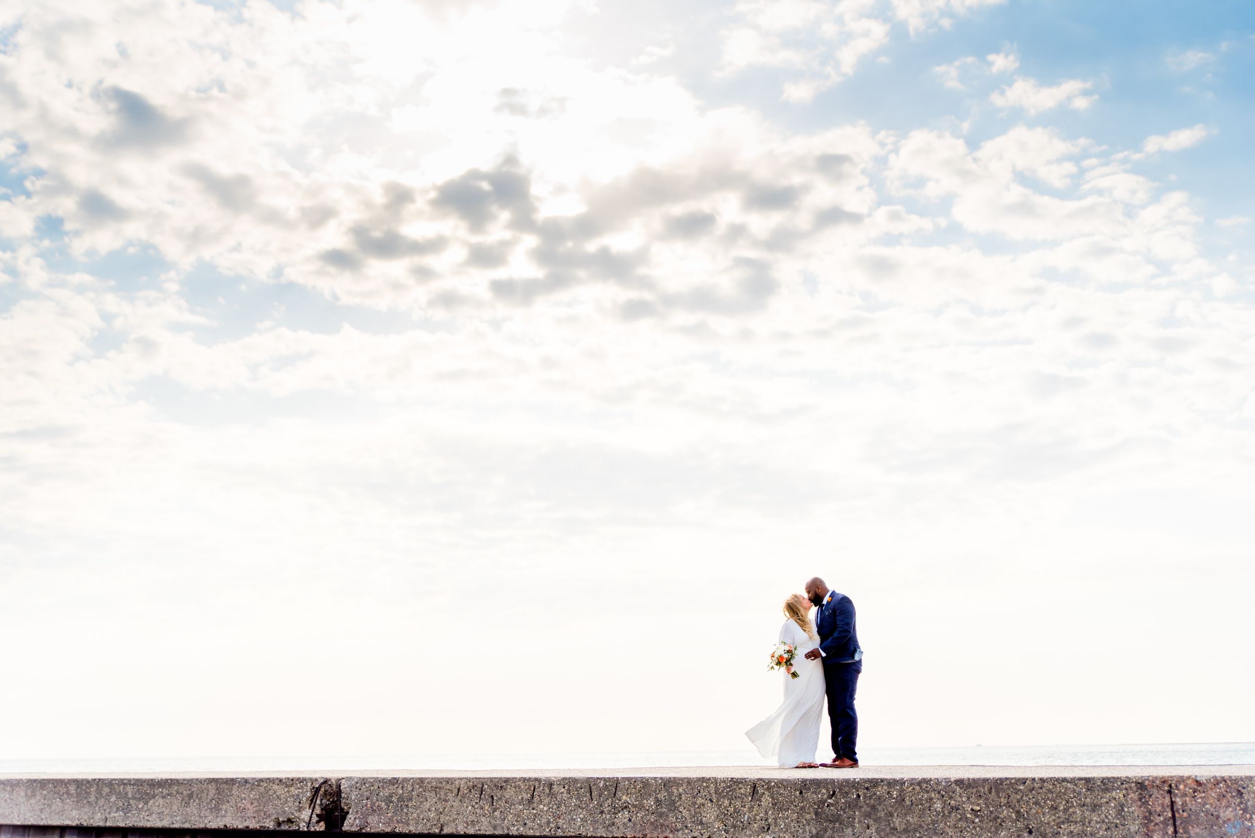 man and woman kissing on pier for north avenue beach wedding photos at sunrise