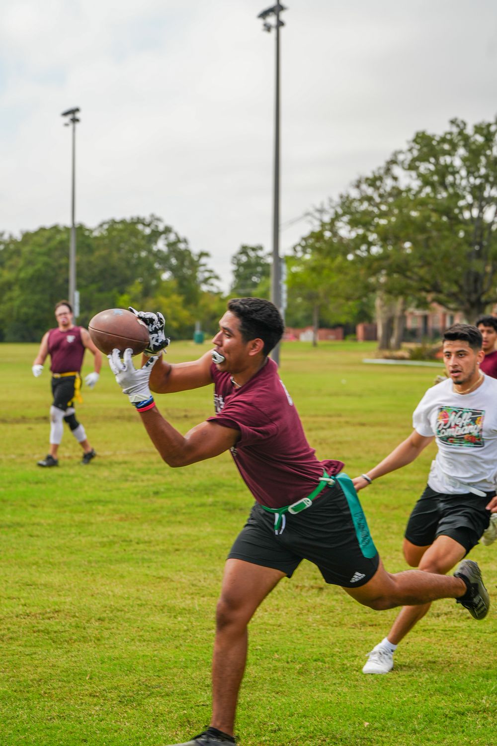 Athletic men showcasing a football catch in Texas, captured through dynamic sports photography.
