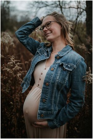 pregnant mom looking off into distance playing with her hair