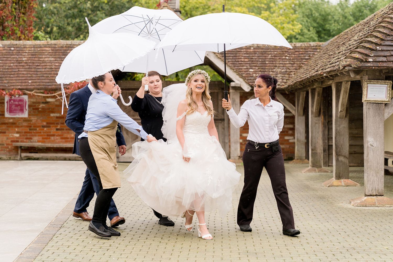 bride walking to ceremony in the rain