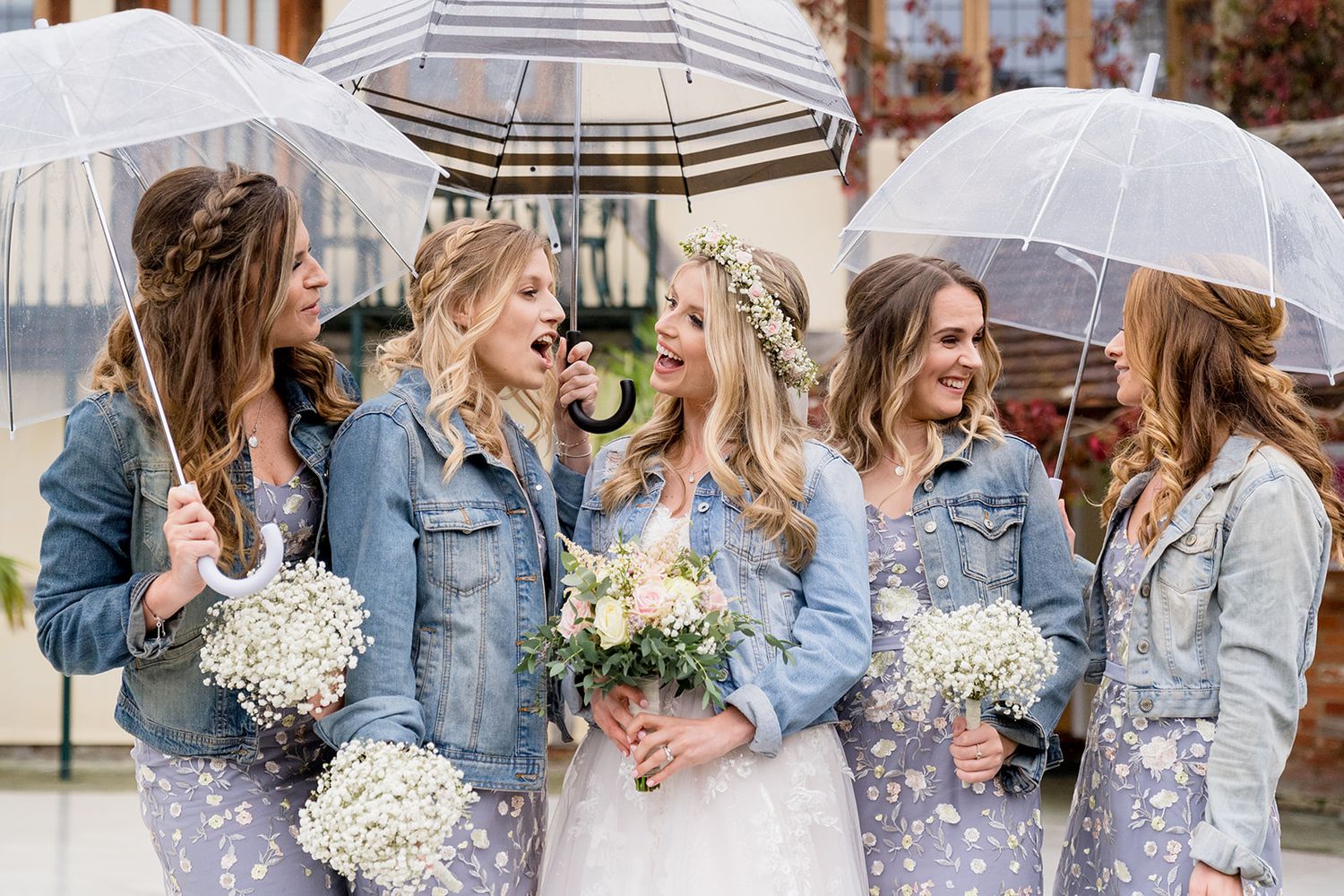 Bridesmaids with umbrellas and denim jackets