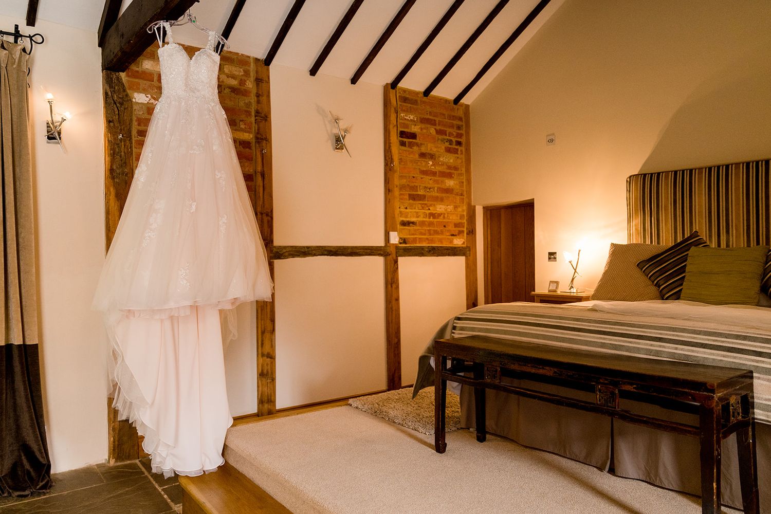 wedding dress hanging in barn hotel room