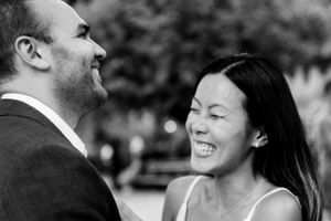 Asian woman and white man laughing together for NYC downtown engagement photos