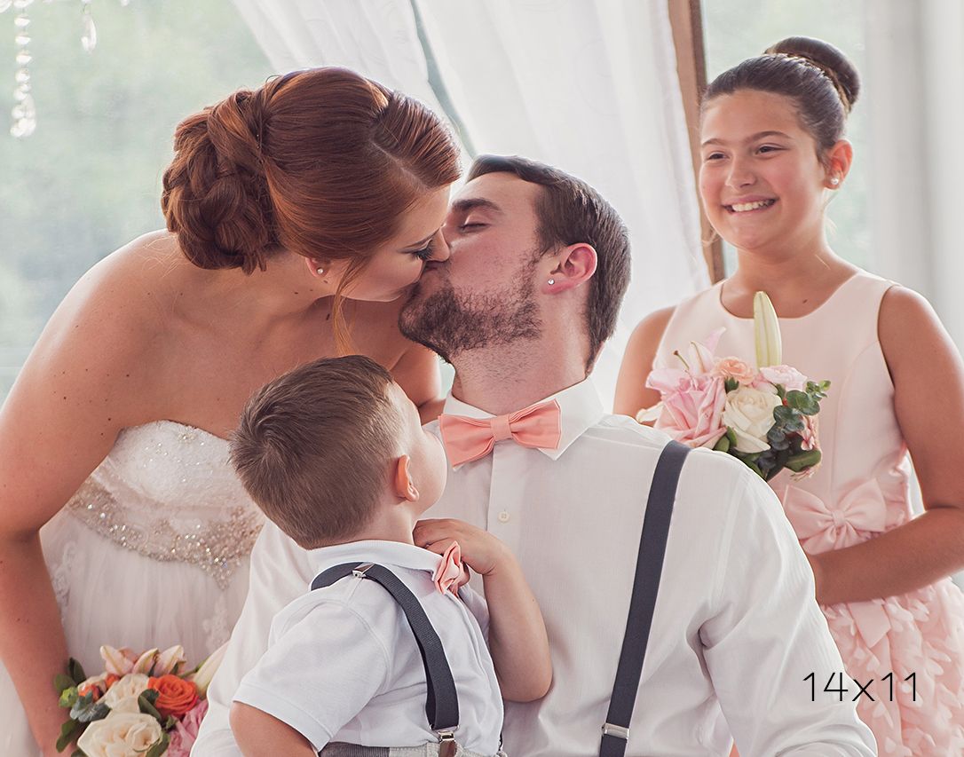 14x11 image of bride and groom kissing while children look on