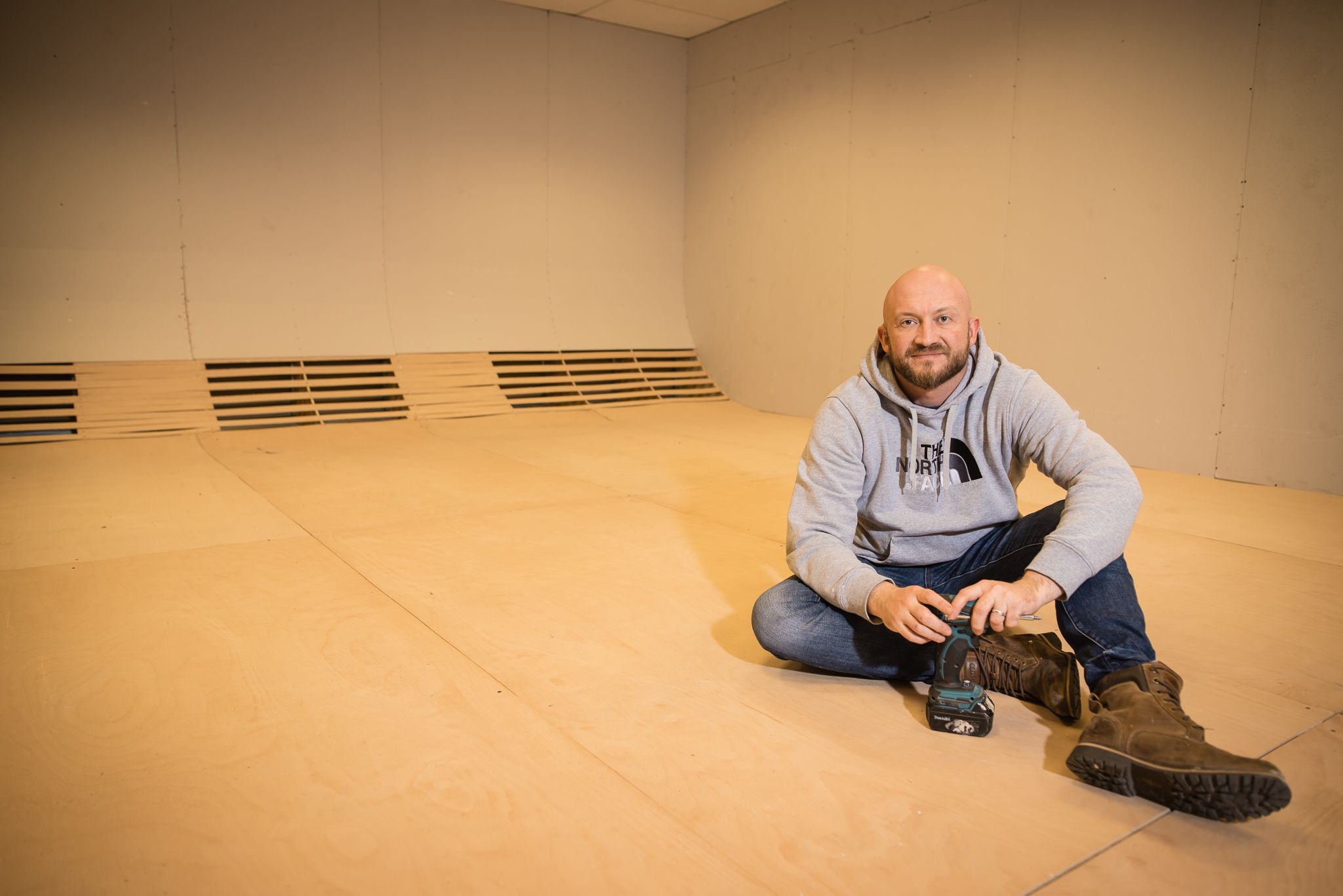 Man building cyclorama infinity wall in a studio