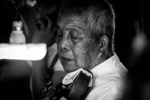 Environmental portrait of fiddle player in Chiang Mai Thailand
