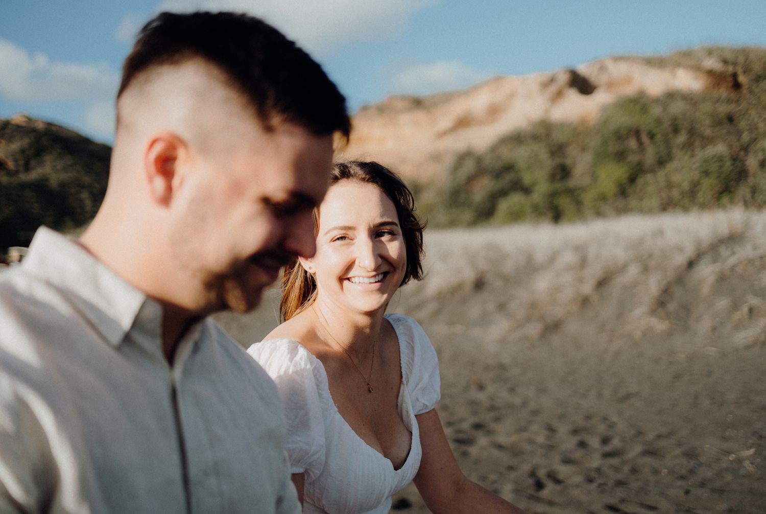 Couple walking during their engagement shoot in Karioitahi Beach with Apertured Media-Auckland Wedding Photographer