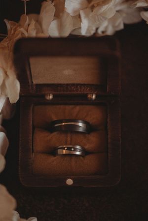 Two wedding rings nestled in vintage brown leather ring box.