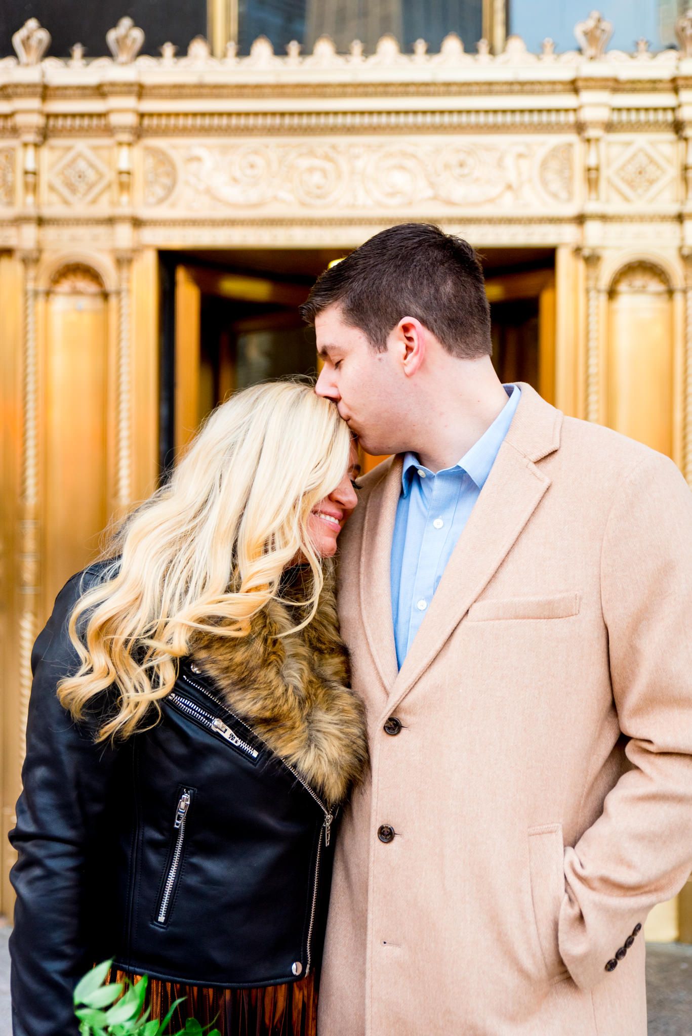 man kissing blonde woman's forehead for Wrigley Building Chicago engagement pictures