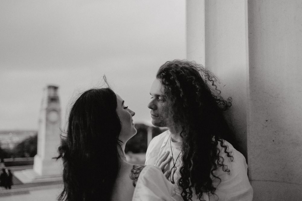 Intimate black and white portrait against a columned backdrop.