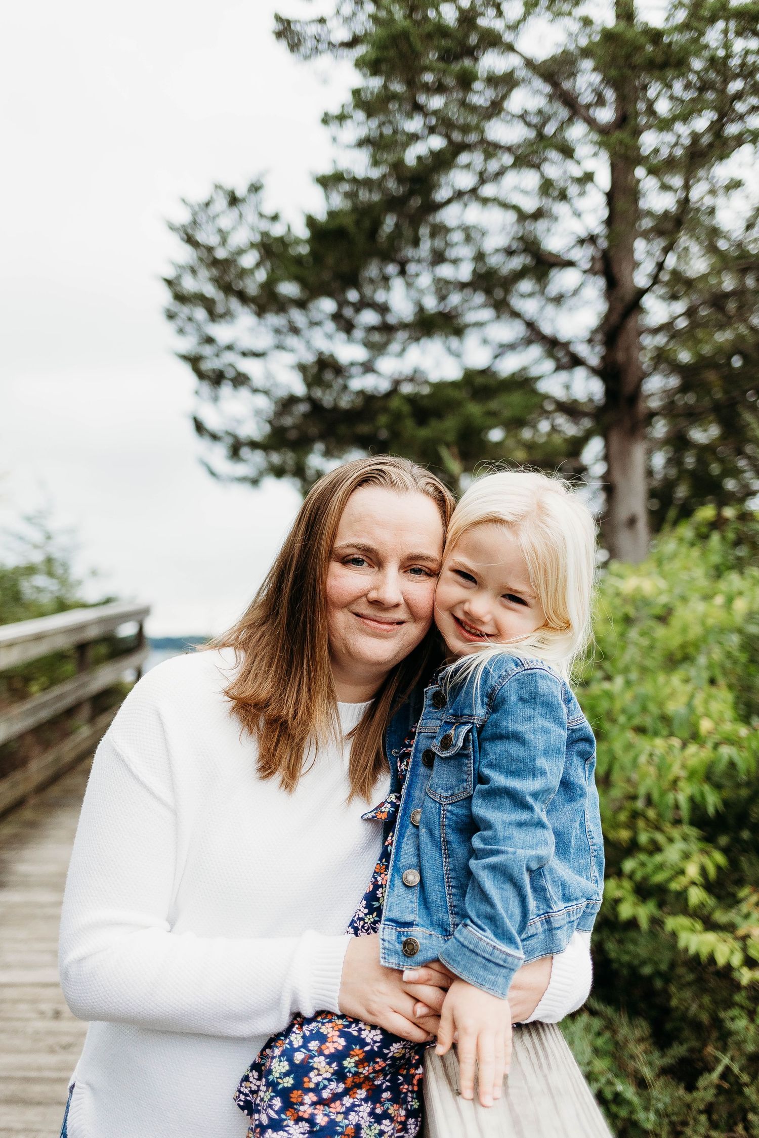 Mom and daugher snuggle cheek to cheek will be take family photos in Nagawicka park Delafield, Wisconsin