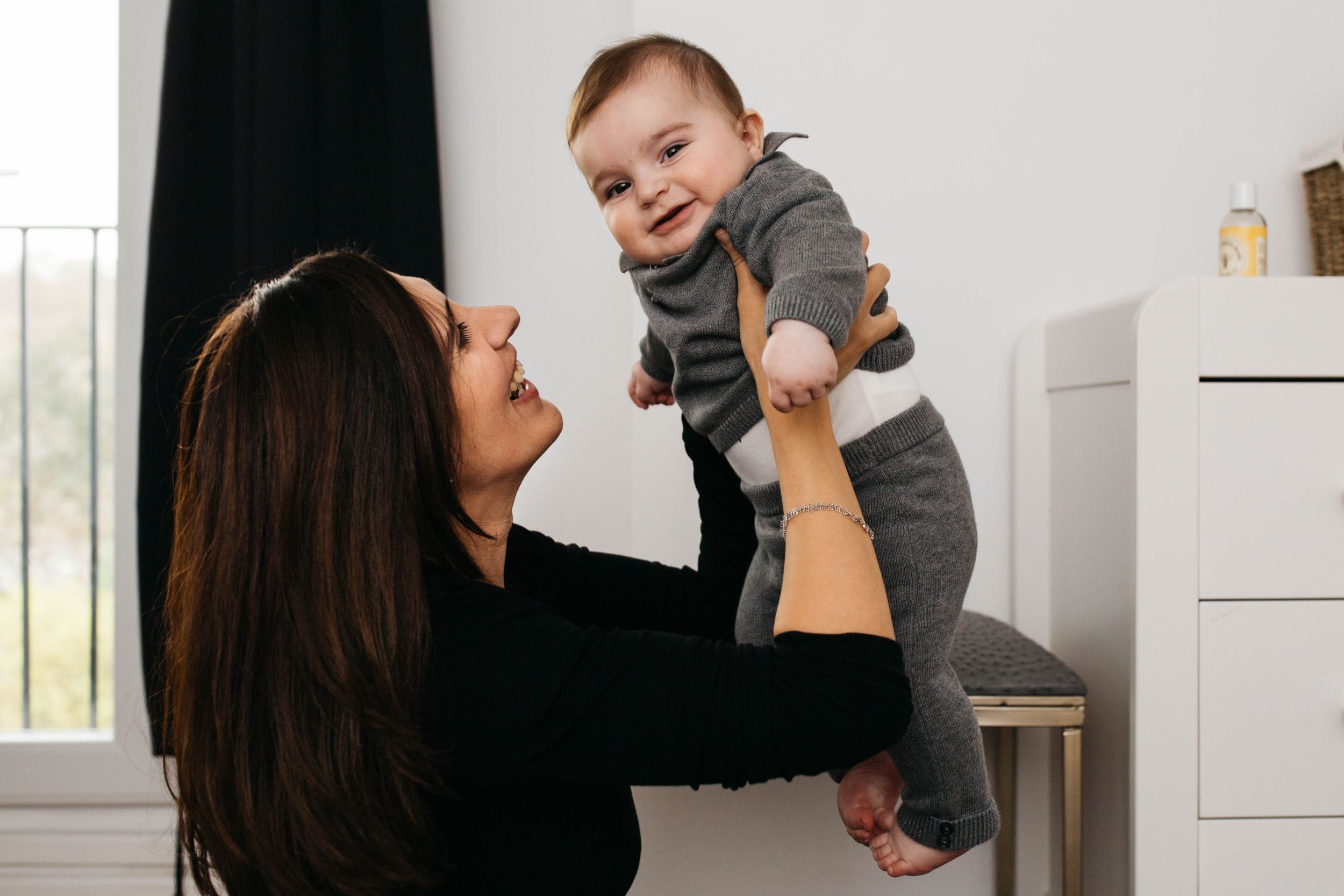 mum lifting baby boy son in air
