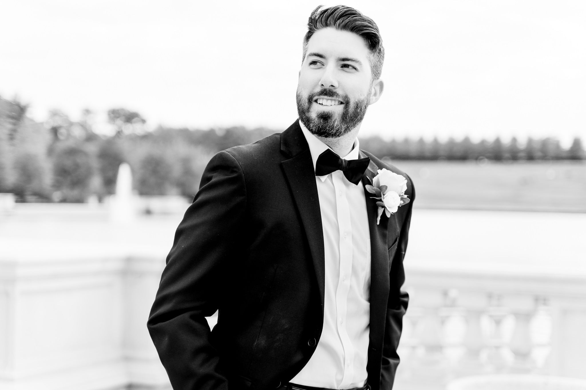 brunette groom with beard in black suit and bowtie smiles off to the side for St. Louis fall wedding