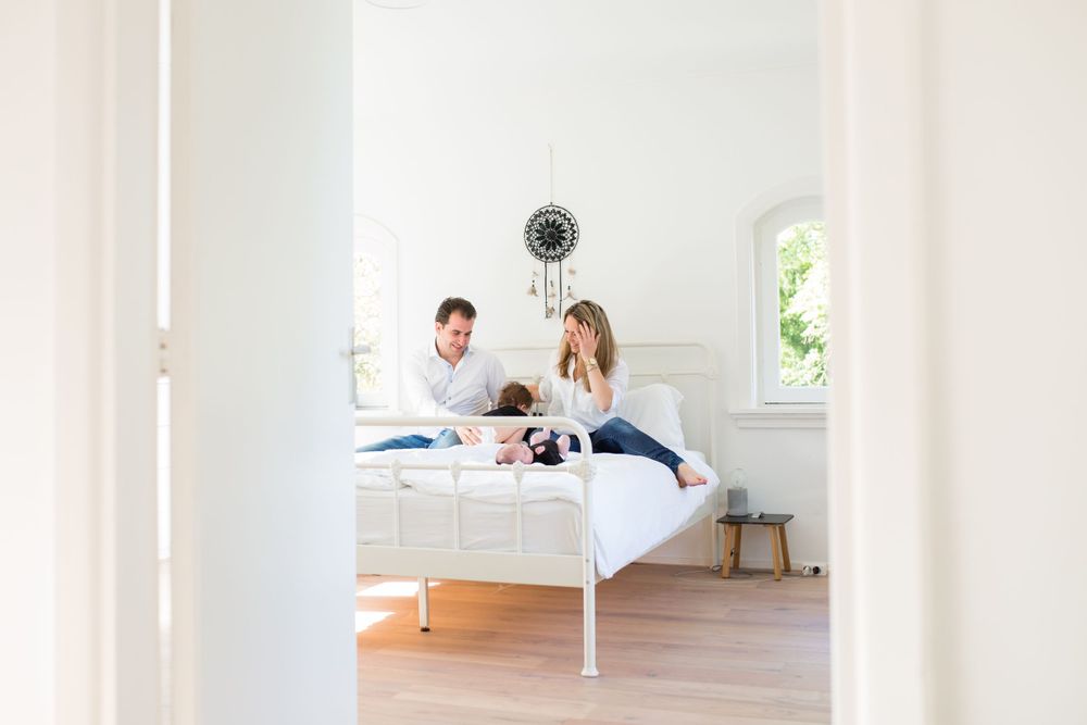 Ouders met baby op bed in hun slaapkamer