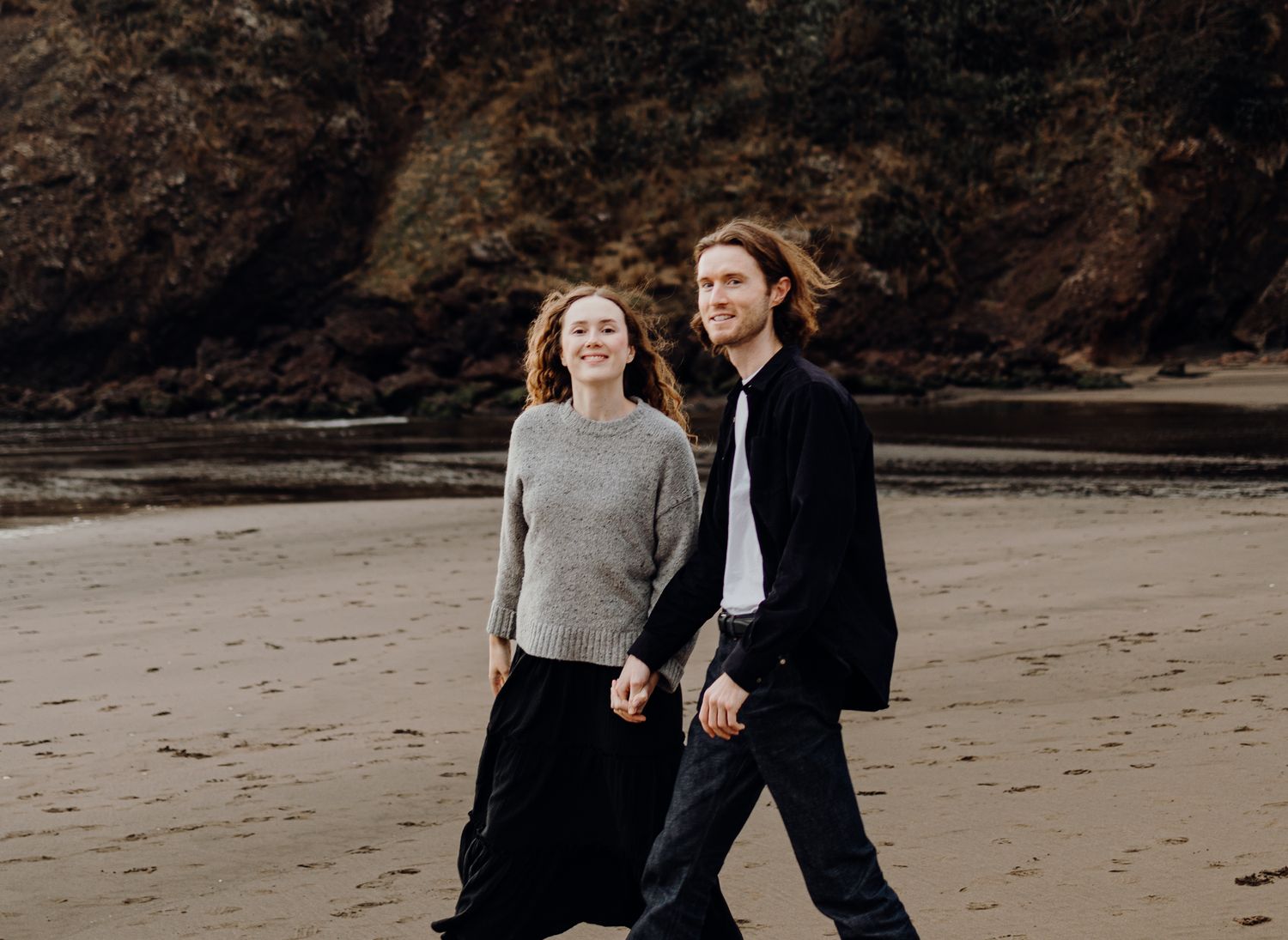 Piha Beach lovers smiling for their engagement session with Apertured Media-Auckland Wedding and Elopement Photographer