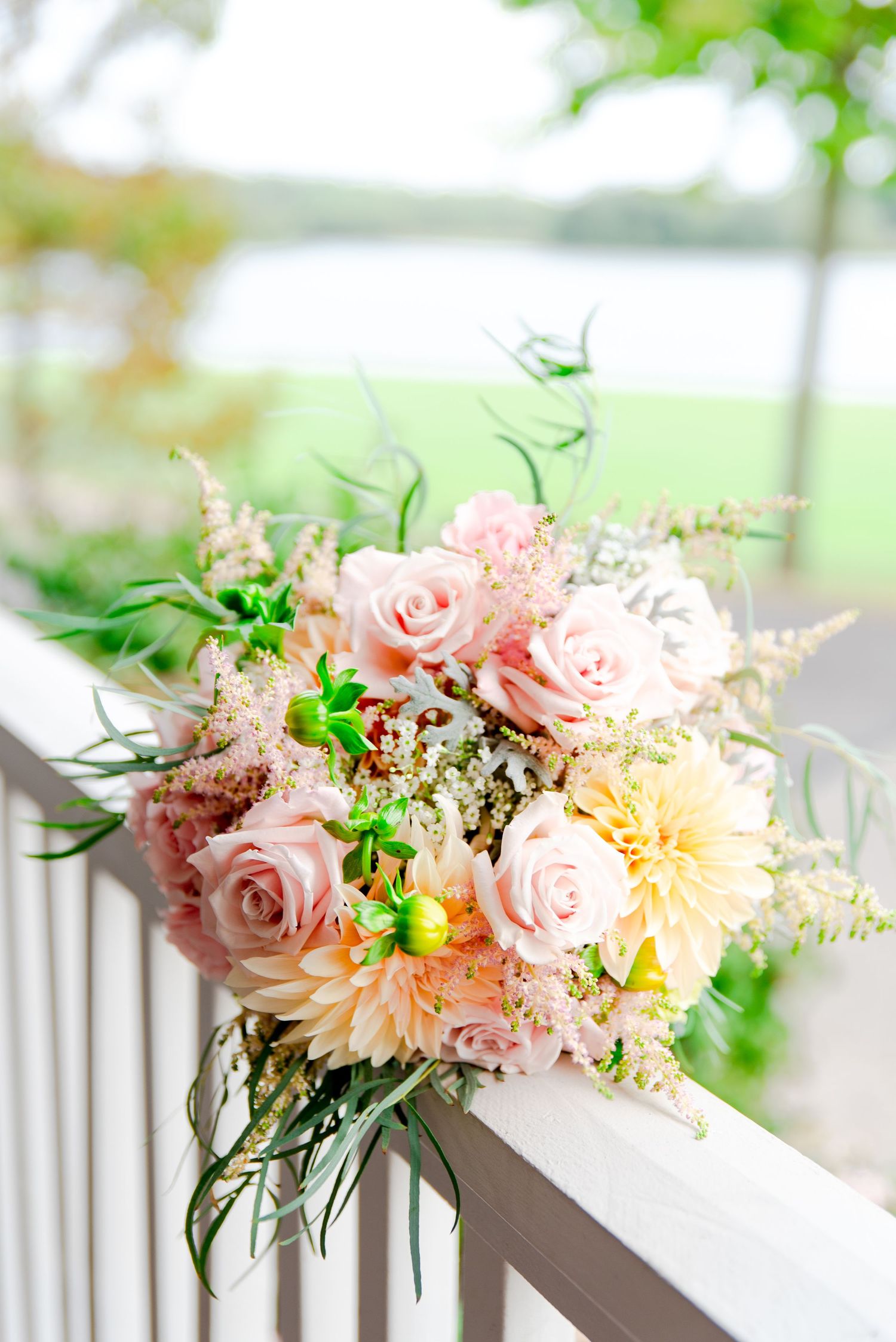 pastel spring wedding bouquet with pink roses and yellow dahlias, plus lamb's ear and pops of neon green