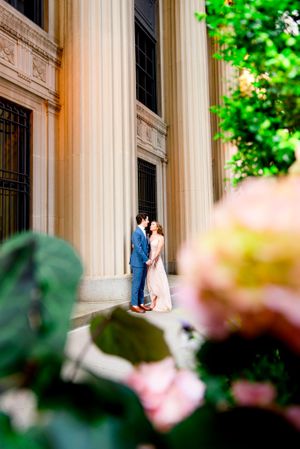 man and woman holding hands looking at each other by the pillars at Chicago Board of Trade for engagement pictures