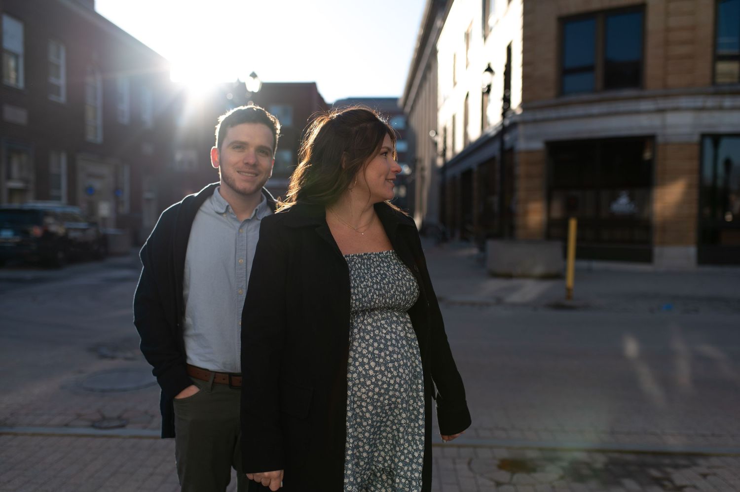 Couple walking together at sunset on a city street with sunflare.