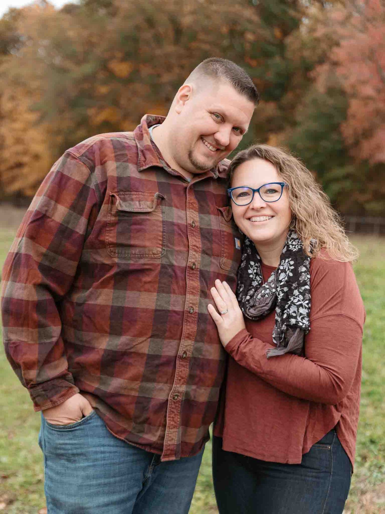 man and woman posing for a couples portrait wearing red flannel