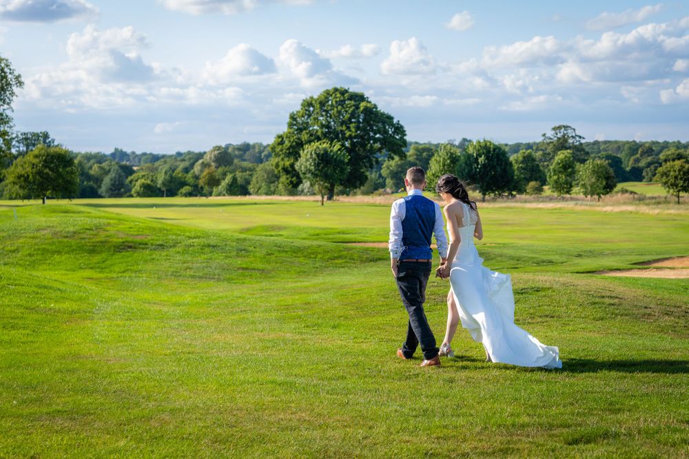 bride and groom walking on golf course