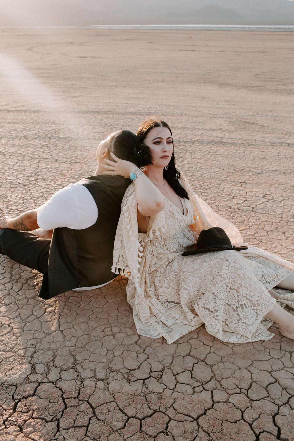 couple sitting on a dry lake bed during their Nevada elopement