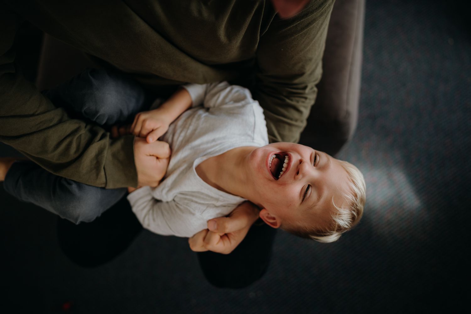 disability family home session Sydney, dad tickling son while son laughs