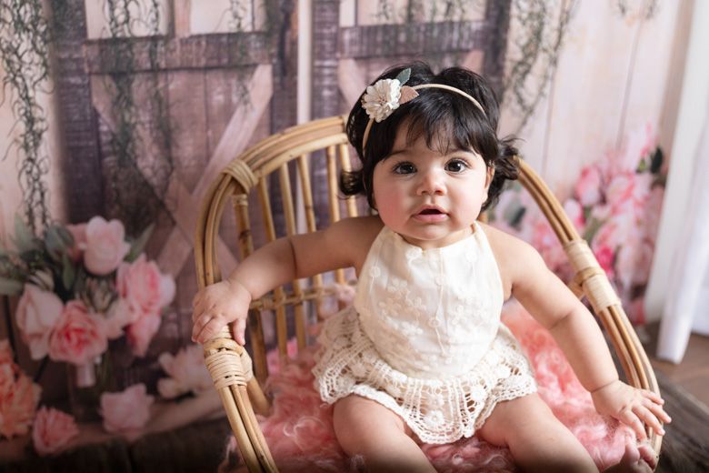 baby girl sitting in a chair in our studio in Lahore