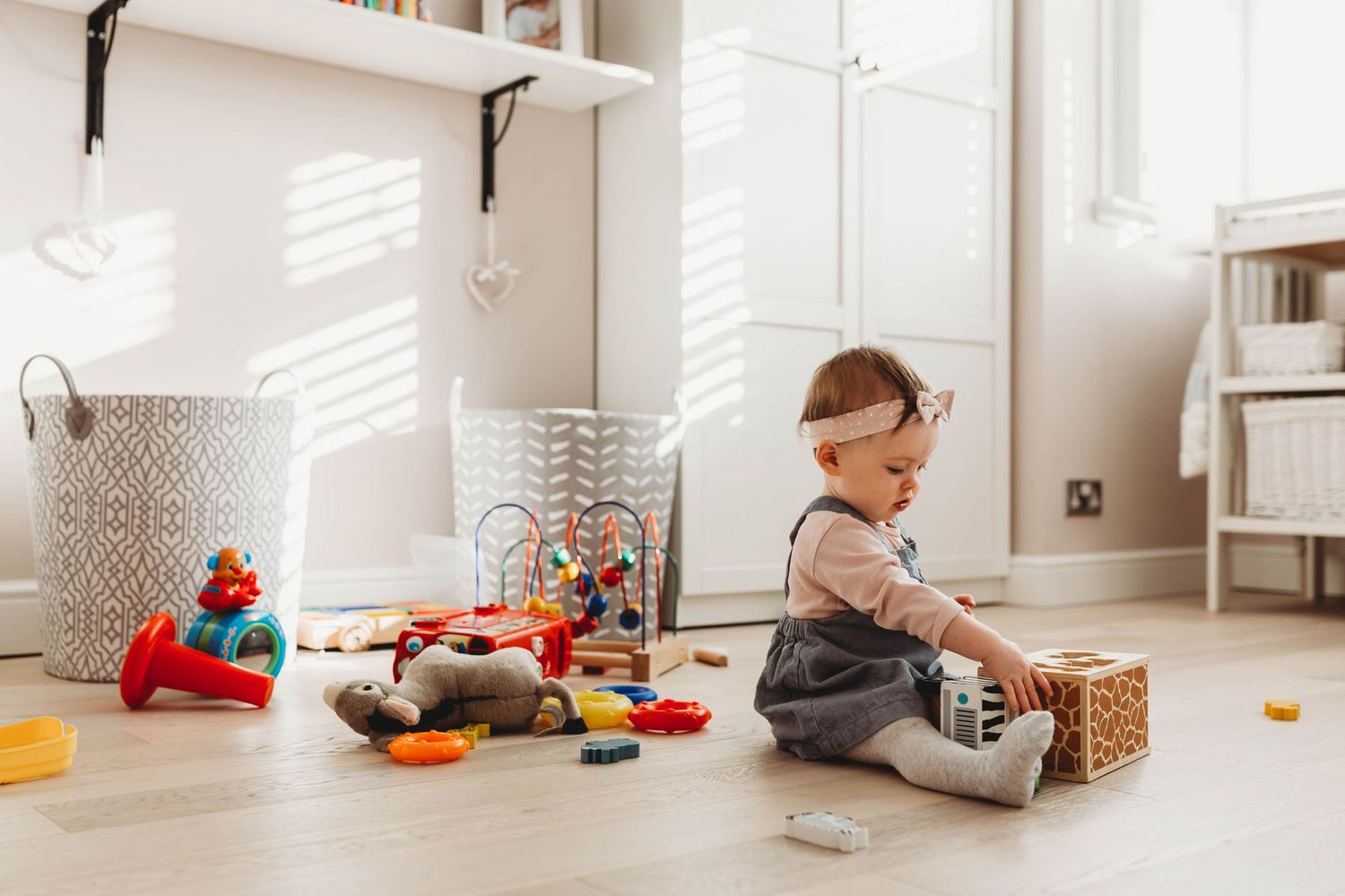 little baby girl playing with wooden blocks on floor