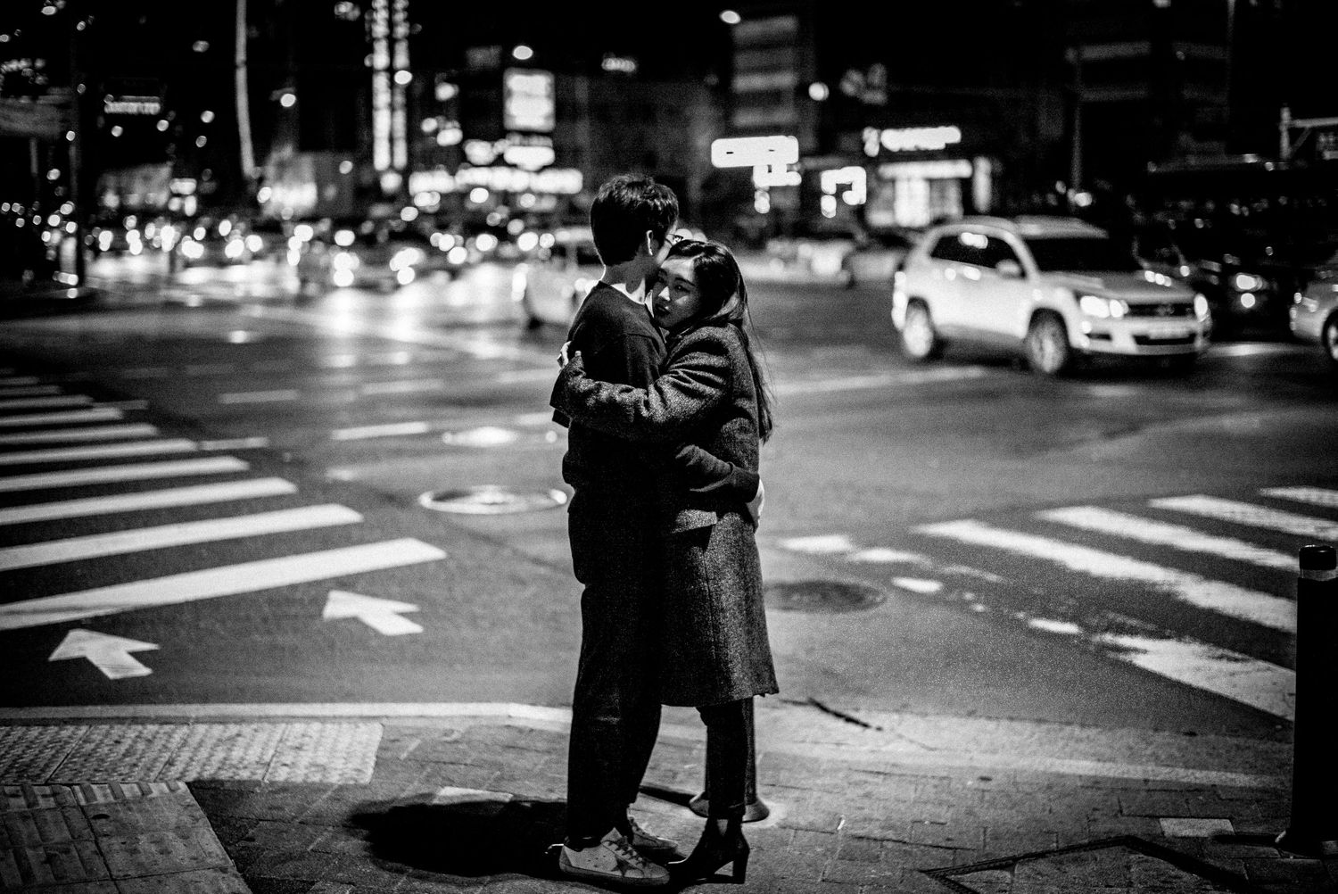 Black and white photo of young couple hugging in street of Soul South Korea