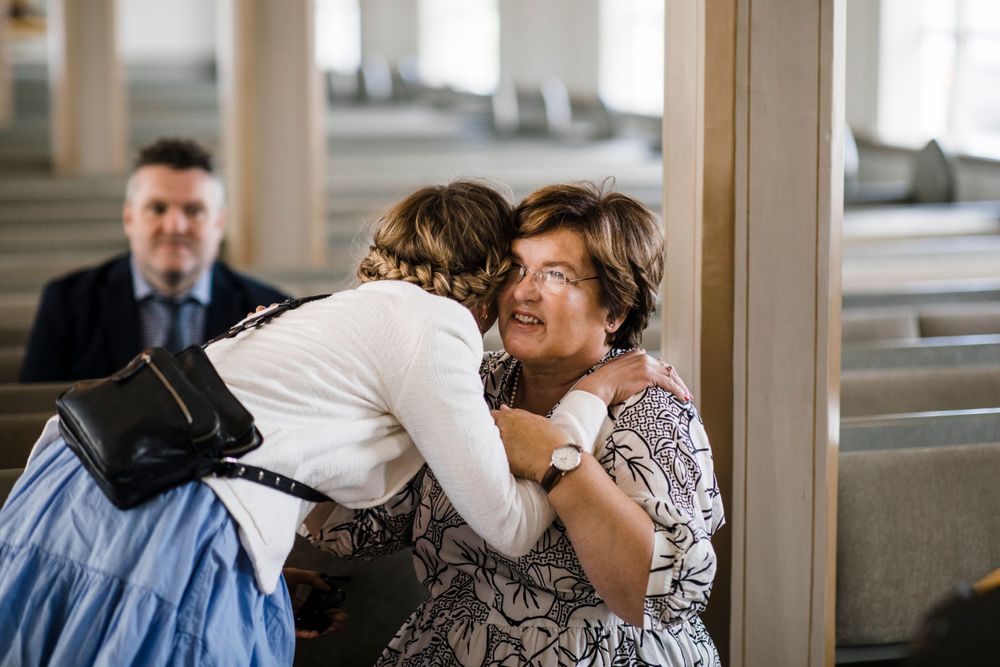 Emotional moment captured in a church pew during a wedding ceremony.