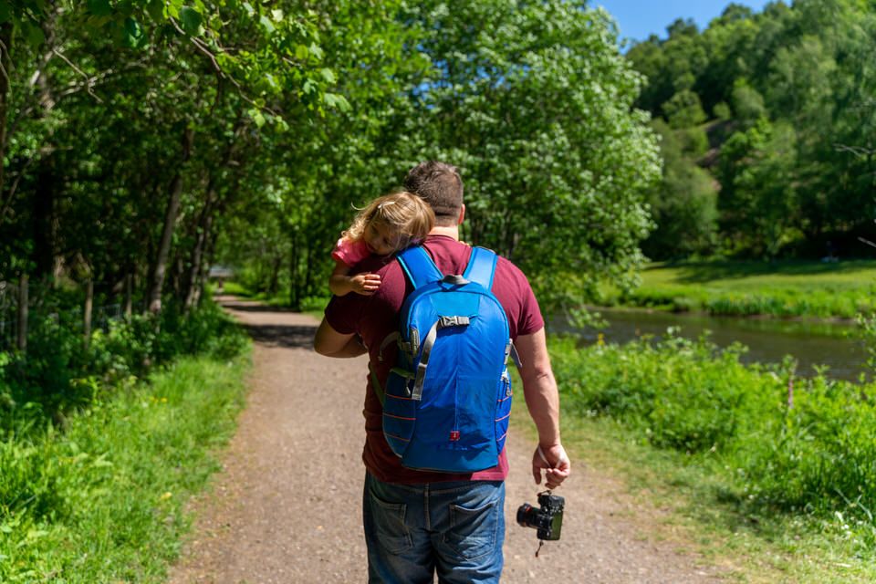 Lloyd Richards Photography carrying his child with camera and backpack