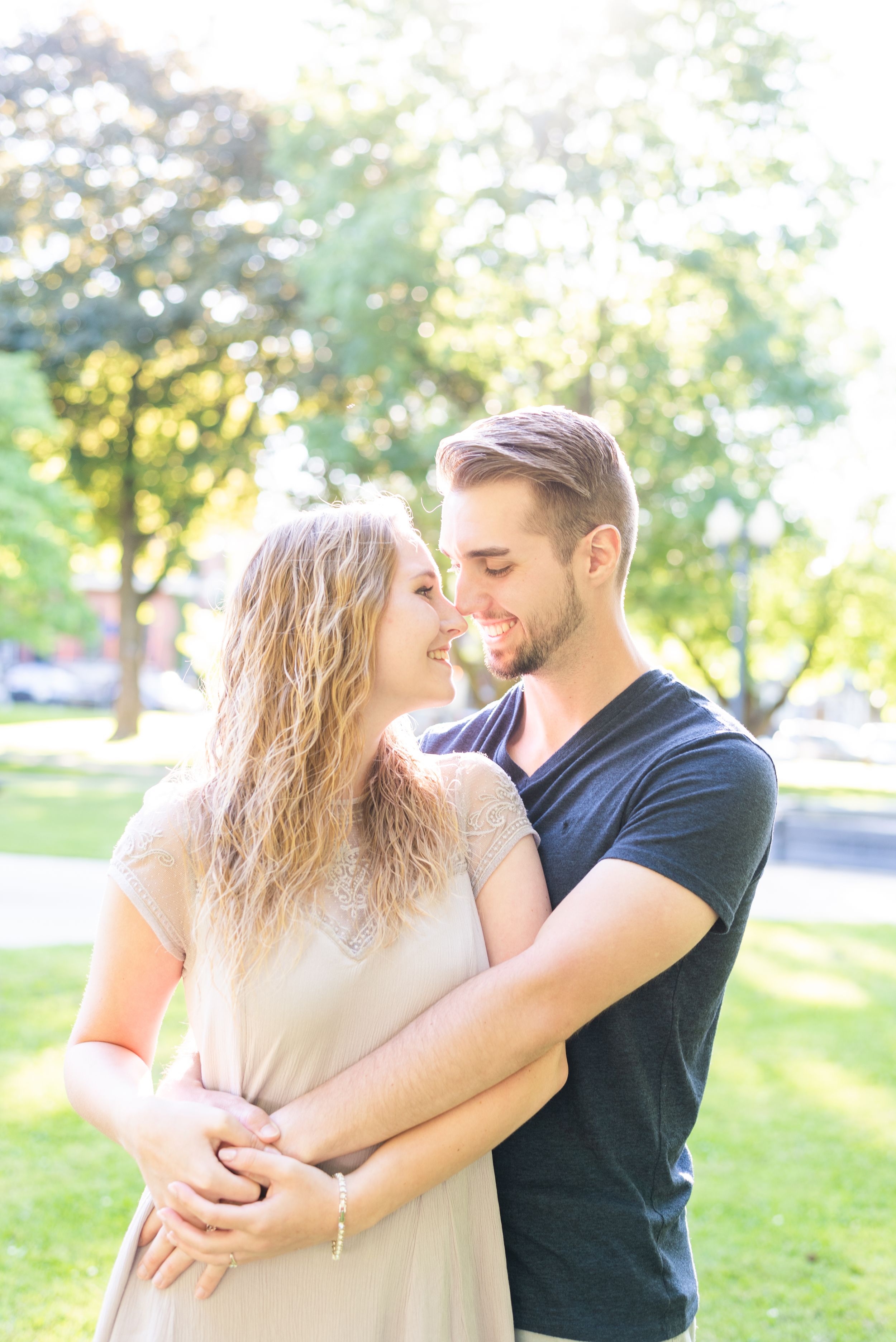 Couple smiling at each other park in sunlight for engagement in Franklin Pennsylvania
