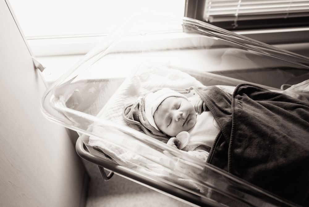 Pasgeboren baby in bedje in het Flevo ziekenhuis. Geboortefotografie is altijd waardevol.