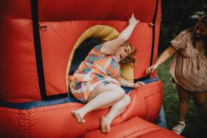 a girl being bounced out of a bounce house.