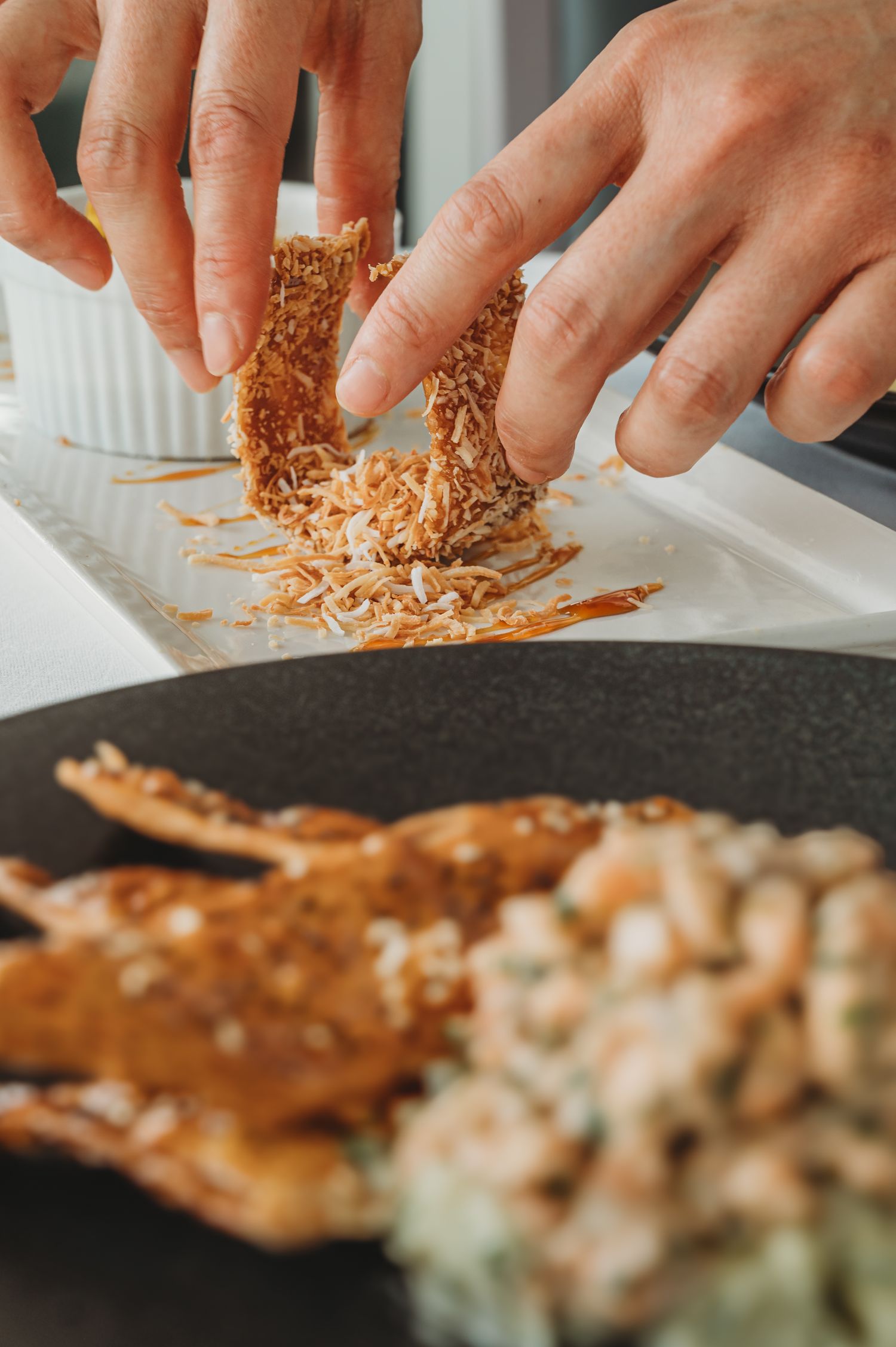 Close up of hands delicately arranging a dessert on a plate in a restaurant. SIX84 Photography, Food Photography, Sydney