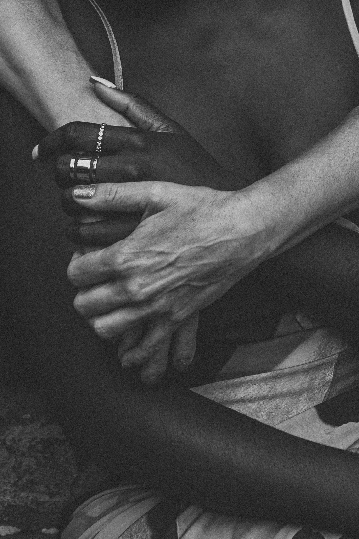 Black and white close-up of intertwined hands, highlighting emotional connection. SIX84 Photography, Portrait Photography, Sydney