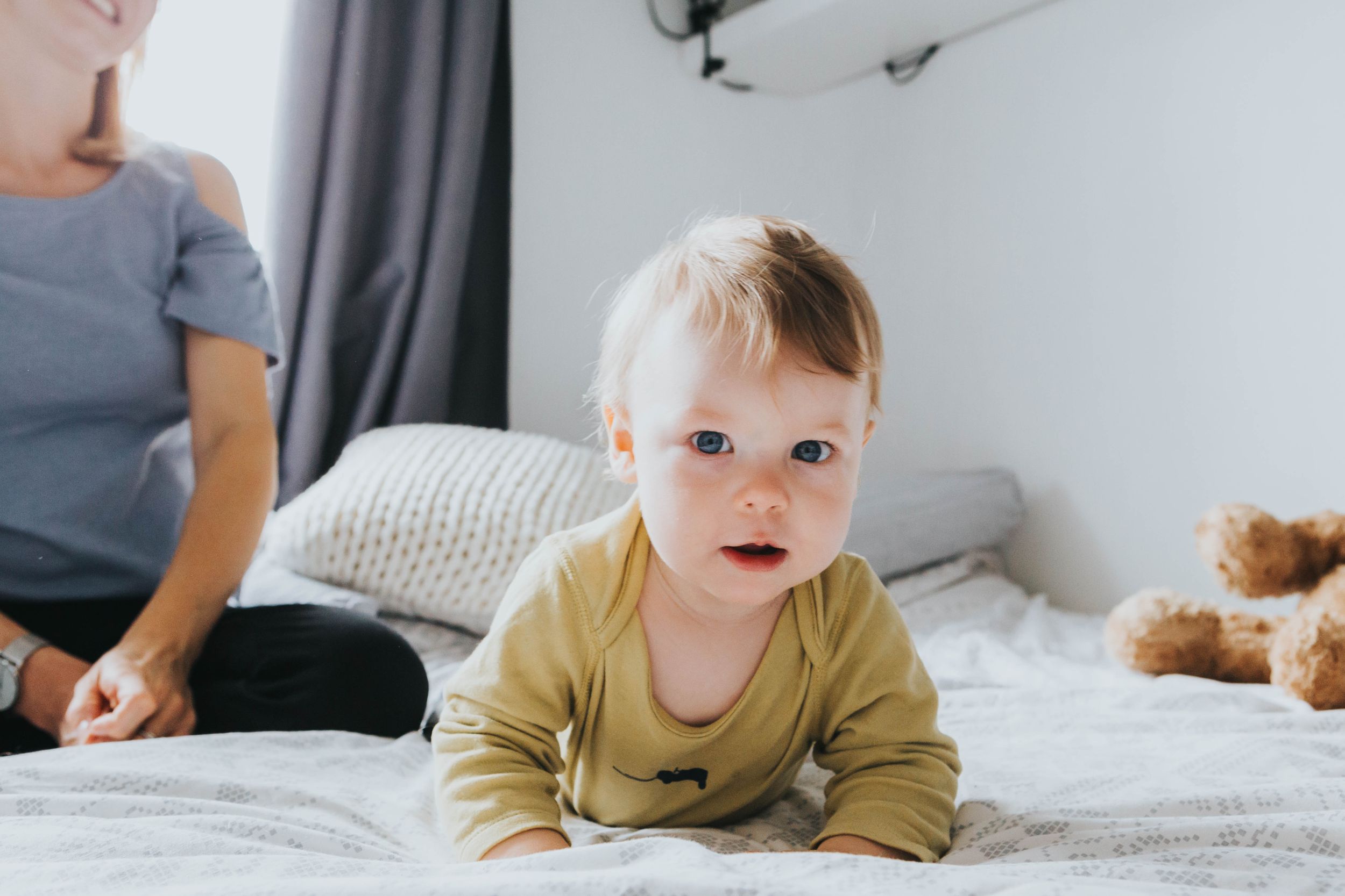 little boy in lime green top on bed