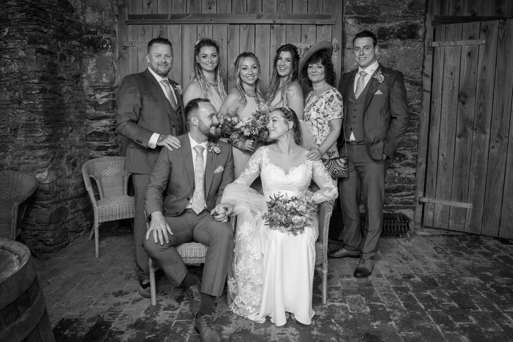 bride and groom with family. Black and white image. Taken in barn at rustic country wedding.