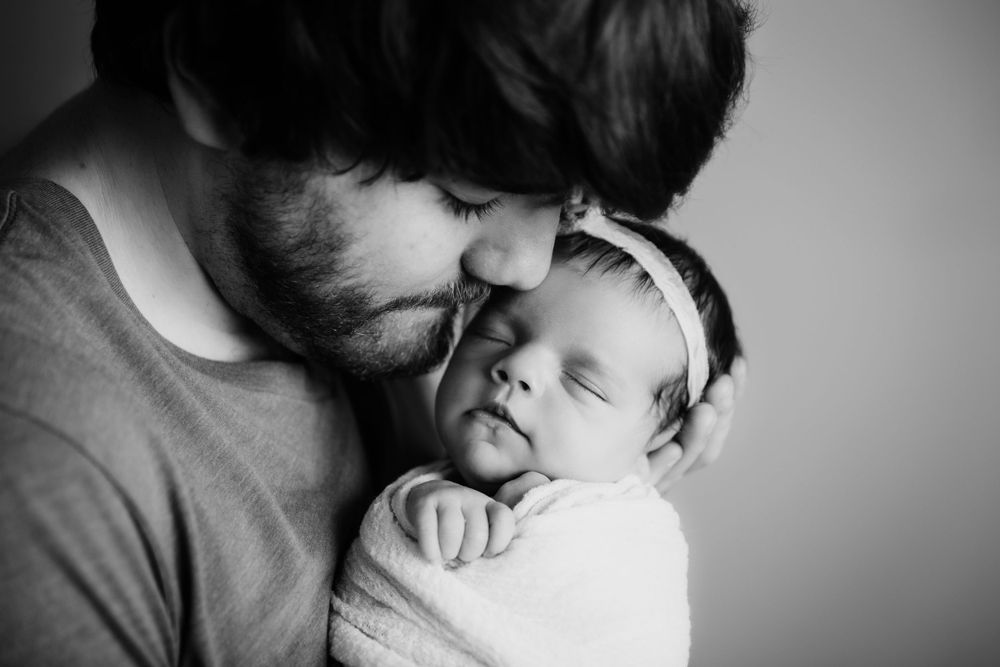 black and white image dad snuggled with baby girl