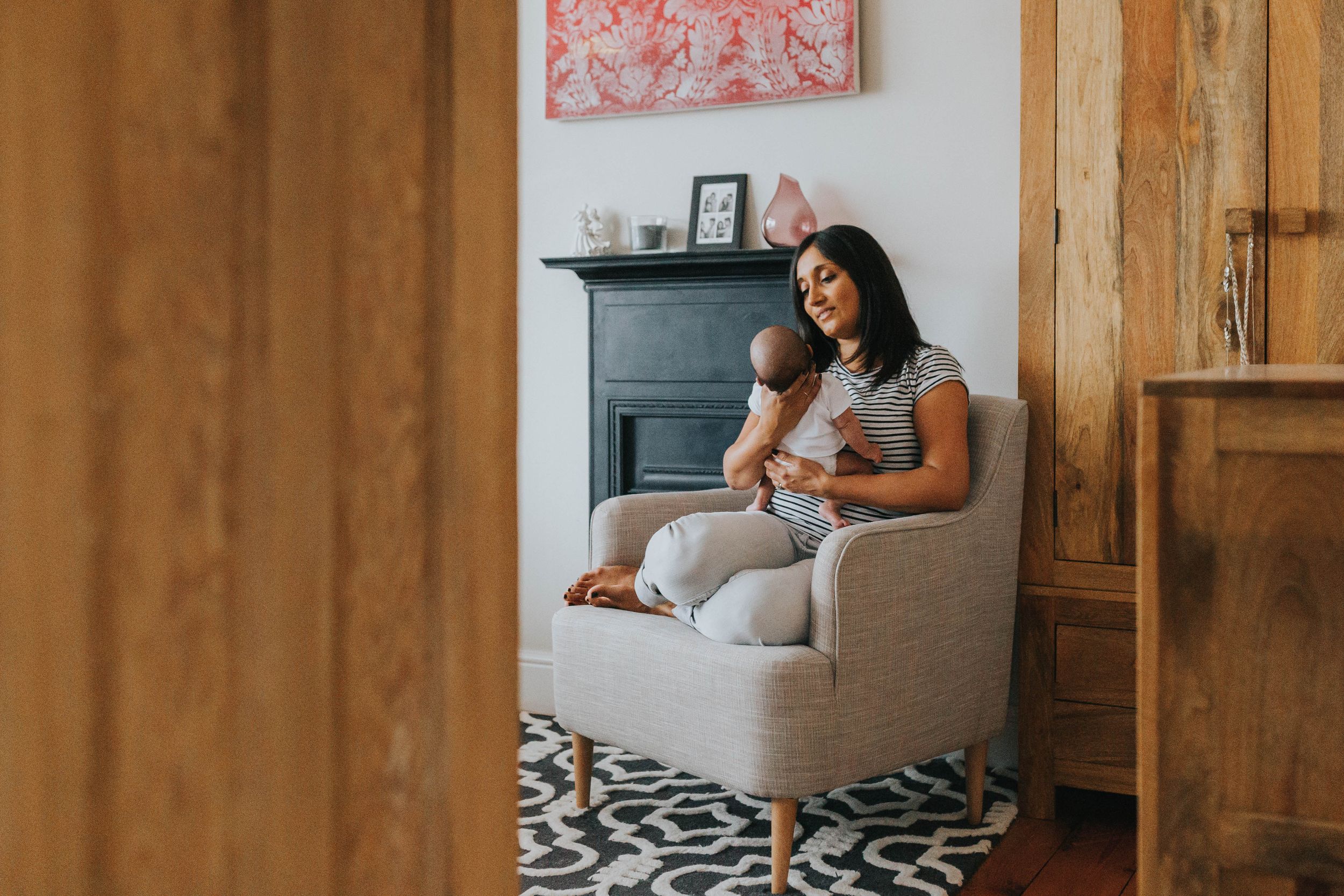 woman sitting with baby in grey armchair