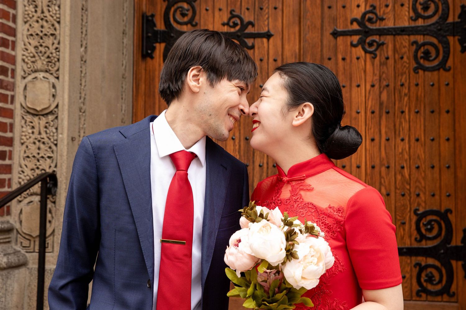 A happy couple shares an intimate moment outside historic church doors.
