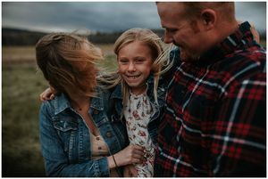 Daughter in between mom and dad shes the only one in focus