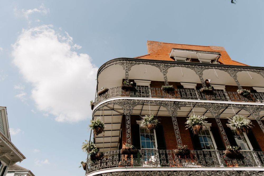 Looking up view of a building in the French Quarter with plants on the balcony, New Orleans Wedding Photographer