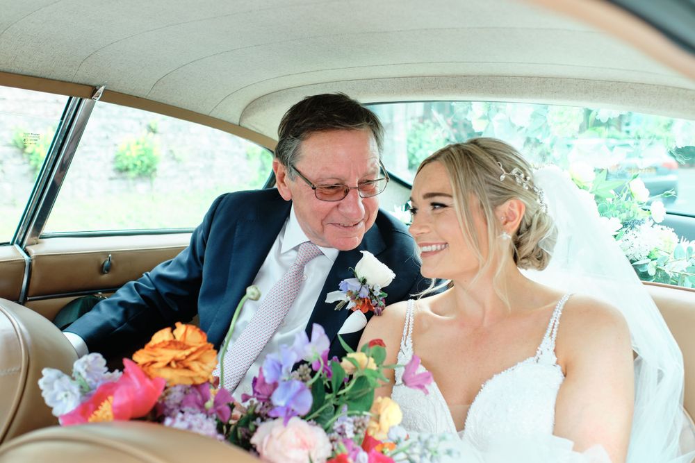A couple shares an intimate moment in the back seat of a classic car.