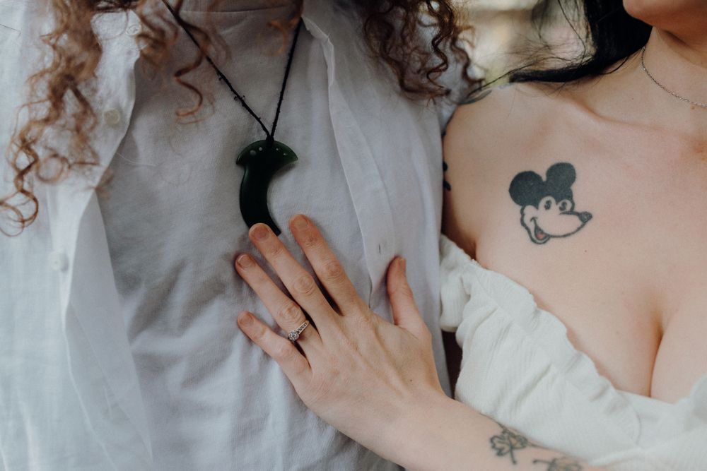 Close up of hands with rings and a Mickey Mouse tattoo visible.