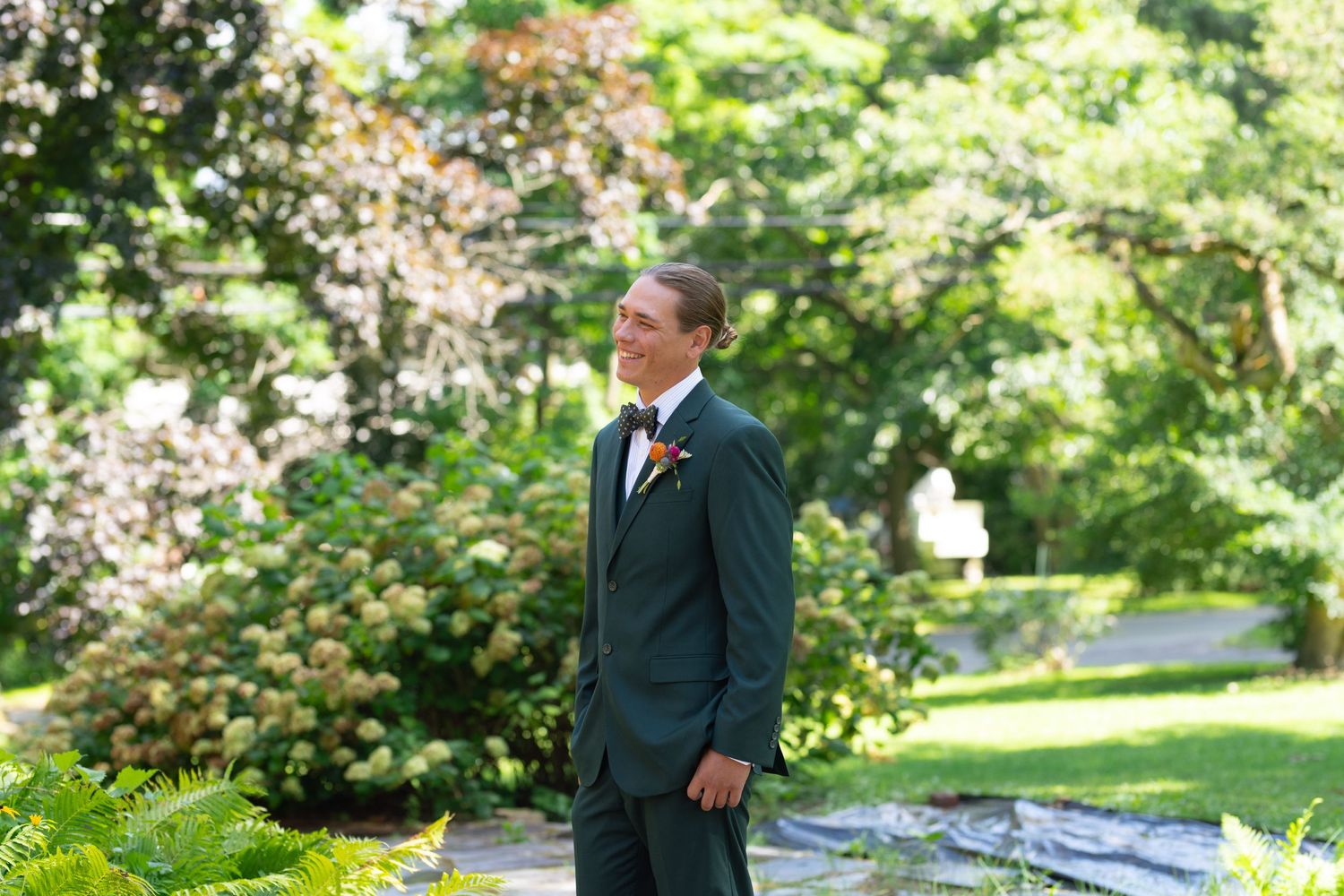 Wedding attire against garden backdrop with blooming flowers and greenery.