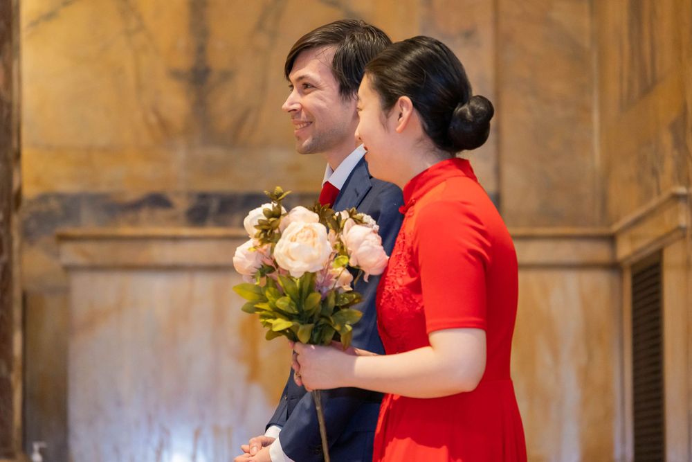 Couple with floral bouquet during church ceremony.